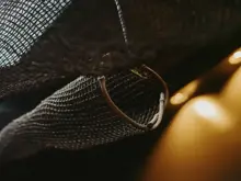 Close-up of a woven mesh decoration or netting, softly lit in a warm-toned interior.