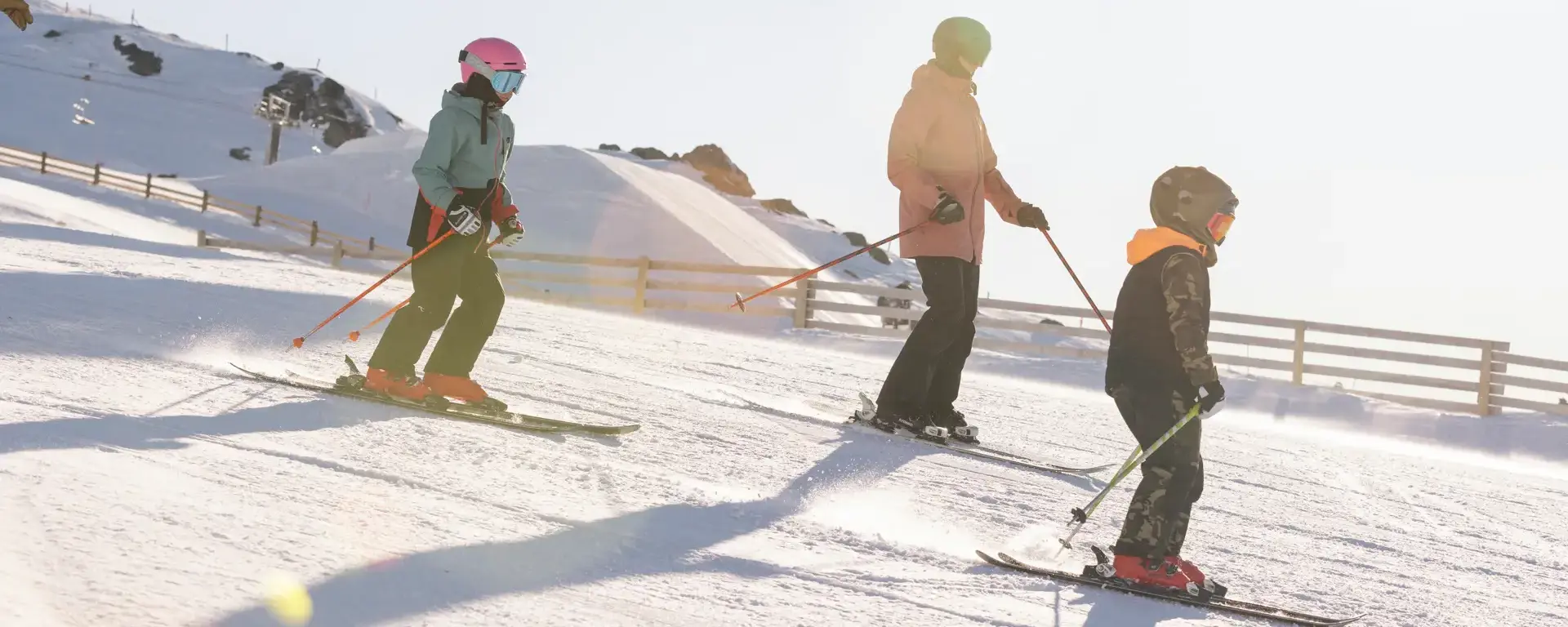 Family skiing together beneath the chairlift at Cardrona Alpine Resort.