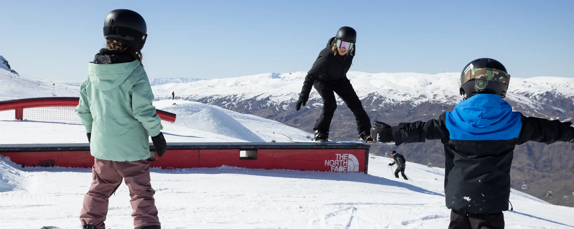 Skiers and snowboarders enjoying the terrain park at Cardrona Alpine Resort.