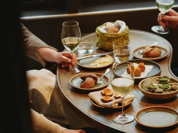 Guests sharing a meal inside a Milford Sound cruise vessel.